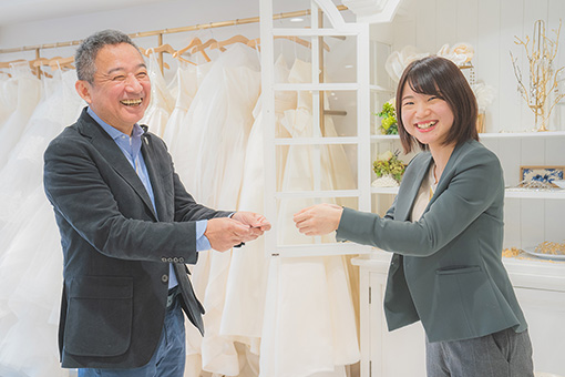 オーナーが女性社員を表彰する写真。2名とも笑顔。