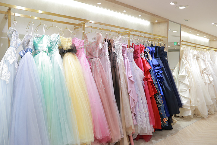 色や形が様々なドレスが写った衣装エリアの写真。