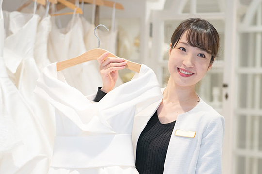 たくさん並んだドレスから1着選定するパートナーの写真。